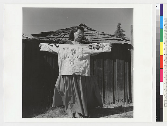 Hearst Museum object titled Black-and-white negative, accession number 15-20231, described as Essie Parrish holding costume; white shirt with abalone decoration, back