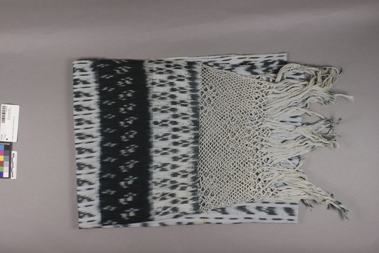 Hearst Museum object titled Shawl, accession number 16-20200, described as Shawl; woven cloth 71 x 67.5 cm; knotting 14 x 60 cm; unknotted fringe 20 cm; white ground with blue ikat; overall ikat pattern of warp-wise narrow and wider stripes. 11 cm wide blue band with white ikat pattern; knotted band of 2 rows of flowers/diamonds 6 at one end; 8 at other end.