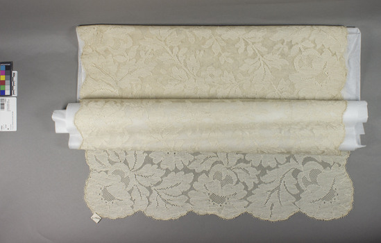 Hearst Museum object titled Shawl, accession number 7-10034, described as Shawl.  Lace shawl, ecru, floral motifs.  “Blonde Spanish lace”.   223cm x 58cm.