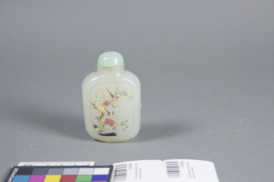 Hearst Museum object titled Snuff bottle, accession number 9-5524a,b, described as Snuff bottle; milky glass; painted in design of birds and flowers on one side, calligraphy on the other, clear glass laid over the paintings; green stone stopper, ivory dipper; height 2 15/16 in