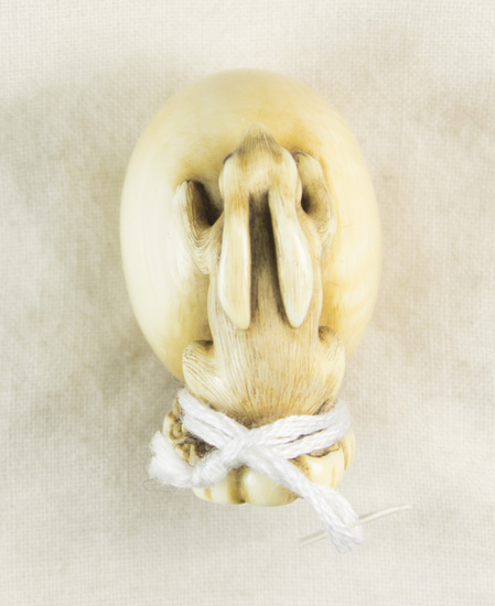 Hearst Museum object titled Netsuke, accession number 9-18808, described as Netsuke; rabbit, standing up and leaning against large ball; base possibly a seal; * signature on base; H 3.3 cm X W 3.6 cm