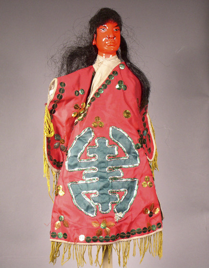 Hearst Museum object titled Hand puppet, accession number 9-22236, described as Puppet, hand.  Red Ghost  A. Head: carved wood, red with black features and hair  B. Body: white cloth, blue cloth legs. Boots:  wood, black and white.  C. Robe: red cloth with green sequins, yellow fringe, green character, "Shou" on front and back 39 x 28 cm (15 3/8 x 11 in)