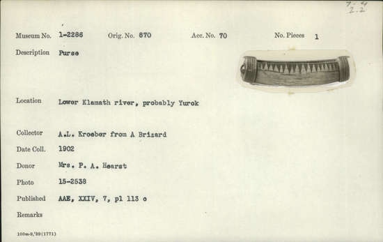 Documentation associated with Hearst Museum object titled Purse, accession number 1-2286, described as Elk antler, curved, oval cross-section; longitudinal rectangular slot at center; tabs on tap at each end; raised flange at each end with four incised transverse bands; transverse bands; triangles incised near slot; red glass bead at one end (missing at other).