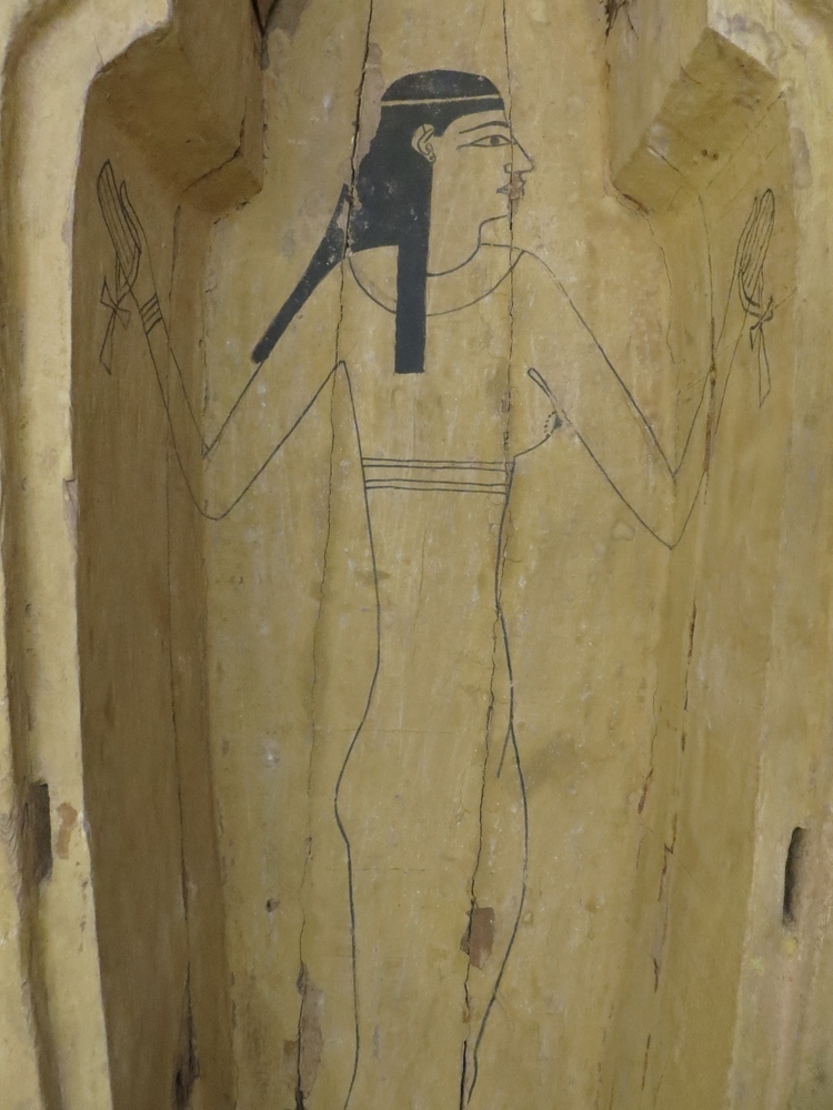 Hearst Museum object 134 of 167 titled Coffin, accession number 6-19912, described as Wooden anthropoid coffin. Inscription running down center of lid. Determined by Kea Johnston to probably be the outer coffin of Iwefaa (6-19928, 12-11039). According to Kea Johnston, "This coffin belonged to a man named Iwefaa, whose name is inserted in the middle of the spells written in the two columns on the front. This coffin is likely the outer coffin for PAHMA 6-19928 based on the similarity of the owner's name, unusual costume, and the paleography of the inscription. Both coffins were purchased on the antiquities market by George Reisner for Phoebe A Hearst. However, stylistically, they are very similar to a set of coffins known to have come from the site of Akhmim, which was excavated in the 1880s by Gaston Maspero, and which has heavily looted for the antiquities market during this decade." "The pectoral vignette between the text and the collar shows the deceased standing before squatting baboon and is the source of our logo. The hieroglyph for 'sky' is above their heads, and the side borders are formed by a pyramid and the symbol for the West.