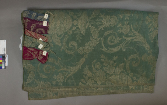 Hearst Museum object 1 of 3 titled Textile sample, accession number 2-62504, described as Yardage; linen, rayon, damask, green ground, light brown designs, floral, foliage and vase motives, Jacquard looms William D. McCann