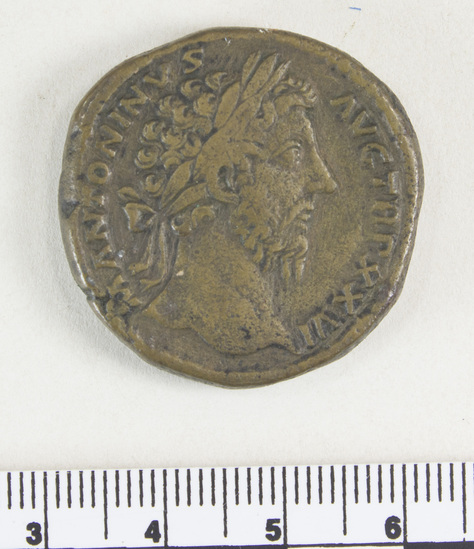 Hearst Museum object 6 of 8 titled Coin: æ sestertius, accession number 8-4867, described as Coin; AE; Sestertius; Roman. 27.23 grams, 31 mm. Marcus Aurelius, 172 AD. Rome, Italy. Obverse: M.ANTONINVS AVG. TR P XXVI, bust r. laureate. Reverse: IMP VI COS III, Roma seated l. on cuirass and shield, holding scepter; in field, S C.