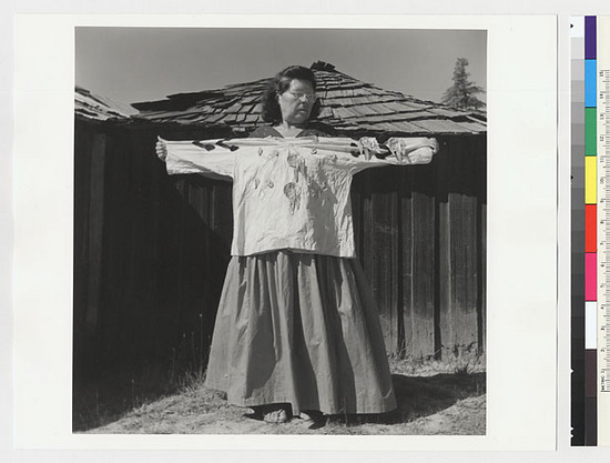 Hearst Museum object titled Black-and-white negative, accession number 15-20230, described as Essie Parrish holding costume; white shirt with abalone decoration, front