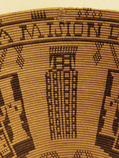 Hearst Museum object 24 of 27 titled Presentation basket, accession number 1-22478, described as Chumash coin-design presentation basket made by María Marta Zaputimeu, early 1800s. Three-rod juncus foundation is sewn with finely split sumac, black-dyed juncus, and a small amount of natural-orange juncus in the base design. The interior of the basket features the coat of arms of the Spanish kings repeated four times. This design was copied from a Spanish colonial coin known as the pillar dollar or piece of eight. The inscription reads "MARIA MARTA NEOFITA DE LA MISION DE EL SERAFICO DOCTOR SAN BVENAVENTVRA ME HIZO AN" (Maria Marta, neophyte of the mission of the Seraphic Doctor San Buenaventura made me [in the year]).  According to Timbrook (2014), "María Marta Zaputimeu (also spelled Saputimehue) was a Chumash woman born at the village of S'omɨs, namesake of the present-day town of Semis. She was baptized at nearby Mission San Buenaventura on June 5, 1788, at about twenty-one years of age (Mission San Buenaventura 1782-1808:No. 363). She had no children and died in 1830." According to Timbrook (2014), close inspection reveals "that fluffy white feathers were inserted horizontally into the foundation on the nonwork face, as the basket was being woven. These appear only on the exterior and are associated only with the four vertical pillarlike design elements that alternate with the shield figures." According to Timbrook, the incorporation of feathers was a stunning departure from Chumash tradition: "this use of feathers is more like that seen in Ohlone and Pomo examples.... and until now has been completely unknown in Chumash basketry."  Diameter: approximately 16¼ inches; height: 6½ inches. About 320 weft strands per inch. Notice: Image restricted due to its potentially sensitive nature. Contact Museum to request access.