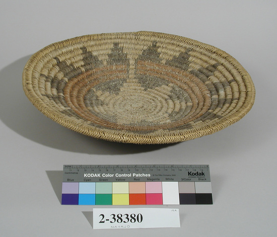 Hearst Museum object titled Basket, accession number 2-38380, described as Coiled. Natural color, broken geometric design in band of brown and black. Round, shallow. Remnants of corn meal in basket.