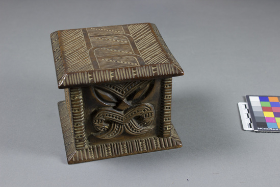 Hearst Museum object 7 of 8 titled Carved wooden box, accession number 11-42799a,b, described as Box and lid, wood, carved in relief, geometric pattern on lid and two sides of box, facial image carved on other two sides of box; tan and brown.