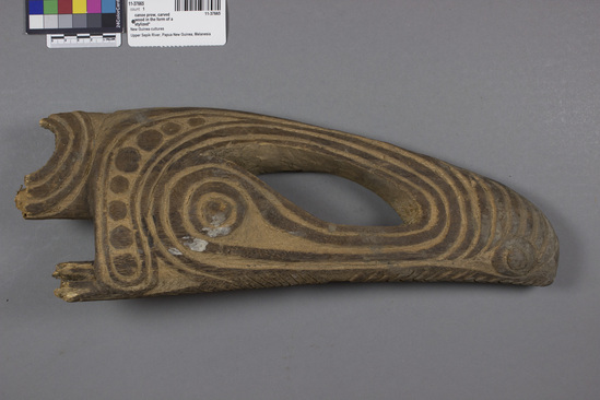 Hearst Museum object titled Canoe prow, accession number 11-37665, described as Canoe prow, carved wood, from a river canoe; stylized head of a crocodile with upturned snout; red pigment in excised areas of design; 40.6 cm 1.