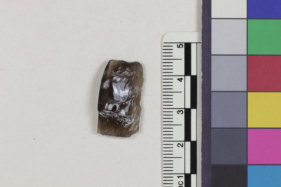 Hearst Museum object titled Flake, accession number 16-14391, described as Projectile point fragment; obsidian; triangular; weight: 1.88 grams; length: 1.4 cm; width: 2.35 cm; depth: 0.49 cm; straight, thinned base.