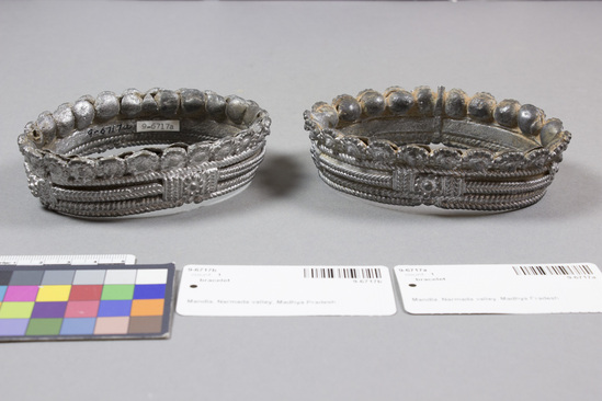 Hearst Museum object titled Bracelet, accession number 9-6717a,b, described as Cast tribal ankle bracelets; “base metal” width 4  1/4 inches.