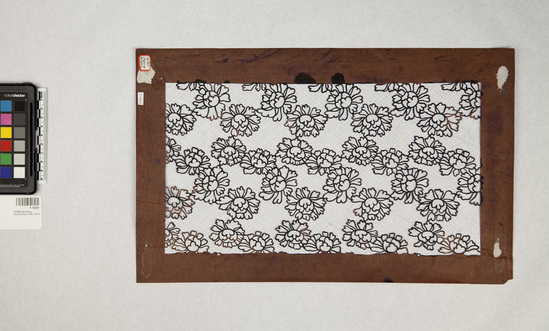 Hearst Museum object 4 of 4 titled Stencil, accession number 9-18200, described as stencil; brown paper with peony blossom design; “a happy xmas” written in white ink on right edge; characters (kanji?) on left; stencil for making katazome (resist-dyed fabric)