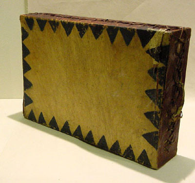 Hearst Museum object titled Drum, accession number 1-255349, described as Rectangular wooden frame covered both sides by rawhide decorated with painted black triangles around perimeter.  Rawhide handles at each end.