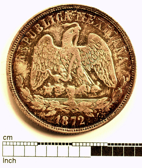 Hearst Museum object titled Coin: 1 peso, accession number 3-23211, described as Silver coin Obverse: “Republica Mexicana 1872”; eagle with serpent in its mouth Reverse: “Un Peso Mo M. 902.7”; Libertad inscribed on a cap which is imposed on a shining sun underneath this symbol is a scale, a sword, and a scroll with “Ley” inscribed on it Denomination: un peso Weight: 27.03 g Content: AR Mint Date: 1872 References: Yeoman 15