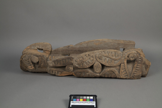 Hearst Museum object titled Canoe prow, accession number 11-37644, described as canoe prow, carved wood; stylized zoomorphic designs carved in relief; tip missing, wide flat rear portion