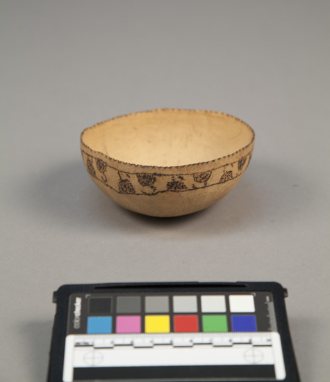 Hearst Museum object titled Coconut shell bowl w/ incised designs, accession number 11-43142, described as Bowl. Coconut shell with incised design around edge, edge notched. diam. - 11.0 cm.