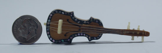 Hearst Museum object 2 of 3 titled Miniature violin, accession number 3-28948a-d, described as Miniature.  Wood violin with bow in wood box with sliding lid. Violin ins inlaid with abalone shell. A-- violin, length. 6.0 cm B-- bow, length. 6.0 cm C-D-- box and lid, 3.5 cm x 7.2 cm. x 1.8 cm