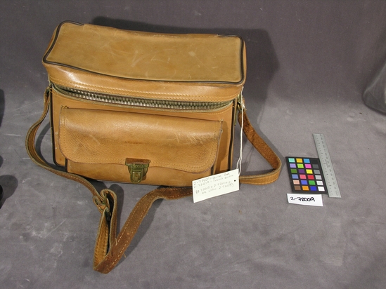 Hearst Museum object titled Camera bag, accession number 2-72009, described as Camera bag: “The Sportsman 592” model.  Camel colored leather w/ brown piping, gold tone metal fixtures, zipper closure, front pocket w/ clasp closure, and non-detachable carrying strap.  W=29.0cm; H=20.0cm; T=16.0cm