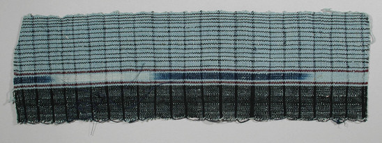 Hearst Museum object titled Textile fragment, accession number 5-11312, described as textile sample (section of narrow band weaving): light blue ground, left panel black, left of center ikat, indigo and white flanked by light blue with central maroon, right panel light blue with narrow black stripes loops left selvage.