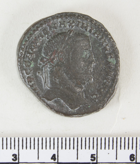 Hearst Museum object 5 of 7 titled Coin: æ, accession number 8-8408, described as Coin, Æ, in bag with other coins and note "Roman per John Smith 7/28/1976." Obverse: face in profile facing left with a garland on the hair. Around edge: ??PCCHLVHL; H; INIHNV????. Reverse: central standing figure holding fronds or a bouquet. Around edge: NIOPOPV; ??OM???.