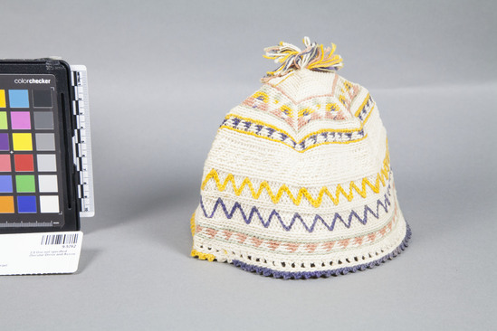 Hearst Museum object titled Cap, accession number 9-5762, described as Embroidered white cotton child’s cap; needle work foundation; pom-pom on top.