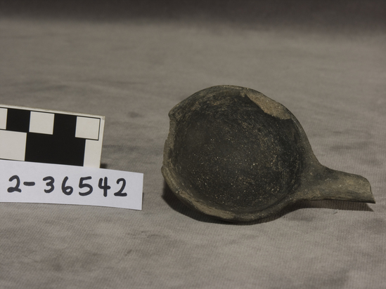 Hearst Museum object titled Ladle, accession number 2-36542, described as Ladle; black-ware. No design, part of handle missing. 2½ inch diameter, 1 inch long.