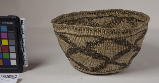 Hearst Museum object 2 of 2 titled Food basket, accession number 1-12601, described as Food basket; twined. Warp and weft are twisted Cattail (Typha latifolia). Brown dye is Tule root (Schoenoplectus acutus). Binding is of Nettle string (Urtica). Large diamond figure in dark red.  "Maska.