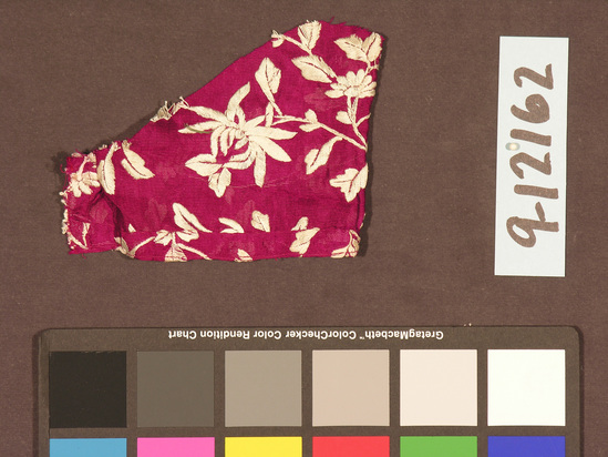 Hearst Museum object titled Textile fragment, accession number 9-12162, described as Sari fragment. Purple silk with white floral brocaded design. Width 22 cm. From India, Maharashtra, Bombay, Parsi.