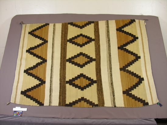 Hearst Museum object titled Blanket, accession number 2-36490, described as Design of parallel stripes and stepped lozenge and triangular figures incorporated.  White, brown, and buff.  Some vegetable dye yarn.