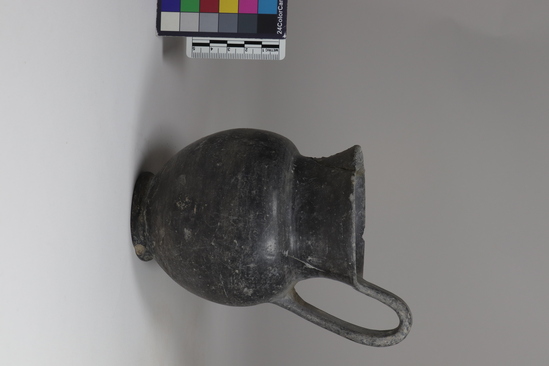 Hearst Museum object titled Jug, accession number 8-1882, described as Ovoid bucchero jug; circular mouth. Description from Matteucig (1951): Jug; height: 12 cm; height to top of handle: 14.8 cm; diameter: 9.5 cm (see Matteucig's plate XXI, 2). Light bucchero. Low concave neck with slightly flaring lip; spherical body on low ring foot; high strap handle. Cf. Not. Sc., 1906, p. 60, fig. 1a, from Bol sena; St. Etr., IX, 1935, Pl. IV, top row, no. 1, from Heba.