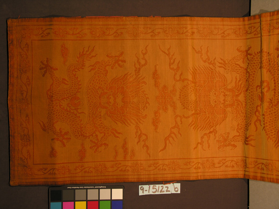 Hearst Museum object 2 of 2 titled Textile panels, accession number 9-15122a,b, described as Two panels. Silk, cotton interlining. Cut pile on colored ground; taffeta lining. Deep yellow; red lining. Design of two dragons, other symbols, floral border bands; taffeta disintegrating. 29 inches by 78½ inches.