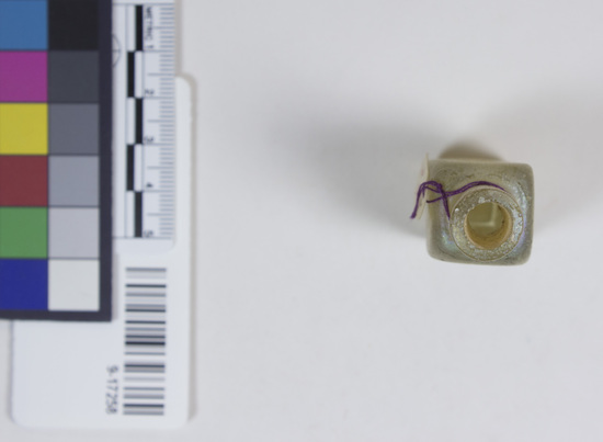 Hearst Museum object titled Jar, accession number 9-17258, described as Jar; for cosmetics (?); clear to pale yellow glass; very t hick walls; long neck has single, ground rim; square body; pontil (?) mark on base.