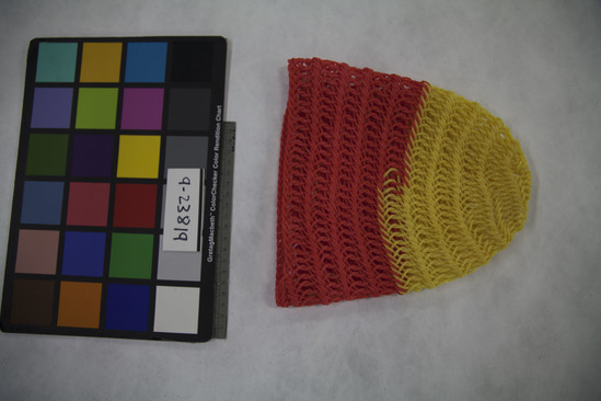 Hearst Museum object titled Snout cover, accession number 9-23819, described as Camel snout cover. A crocheted, circular bag made of plastic rope and closed at one end. It may be double crochet. Have never seen one made, but they are common everywhere that are camels. This one is yellow and red but they come in all colors. Used to keep camels from biting or eating. Frequently used in transit and in camel markets.