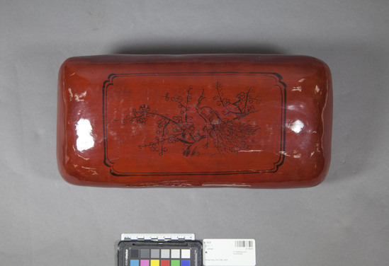 Hearst Museum object 3 of 3 titled Pillow, accession number 9-13639, described as pillow; lacquer; rust brown with black designs of peacock and cherry blossoms, landscape; summer use.  Believed to be cooler in summer than stuffed cloth pillow.  From Mainland China