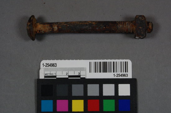 Hearst Museum object titled Bolt, accession number 1-254963, described as Rusted iron bolt with square nut attached and threading. Bolt has round concave head