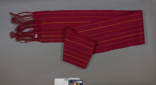 Hearst Museum object titled Sash, accession number 3-29, described as Waist band of man (faja); red cotton, yellow striped; long braided fringe on ends; 143 cm long, fringe about 15 cm long; 15.5 cm wide