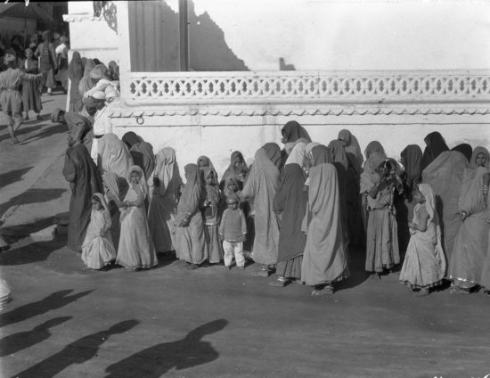 Hearst Museum object 4 of 4 titled Black-and-white negative, accession number 15-30707, described as 4 x 5" Negative. Udaipur, Rajputana, India. Image of women and children, citizens of the region, within Rai Angan (Royal Courtyard) for His Highness The Maharana's birthday procession.