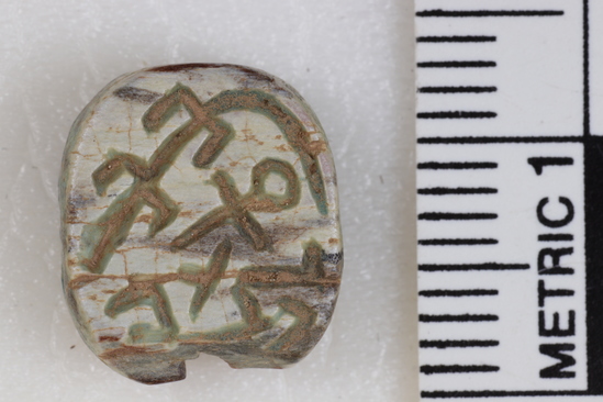 Hearst Museum object titled Seal, accession number 6-13581, described as Green seal; almost circular, broken perforation, inscription on both sides. Length 12.4 mm, width 11.1 mm, height 5.2 mm.