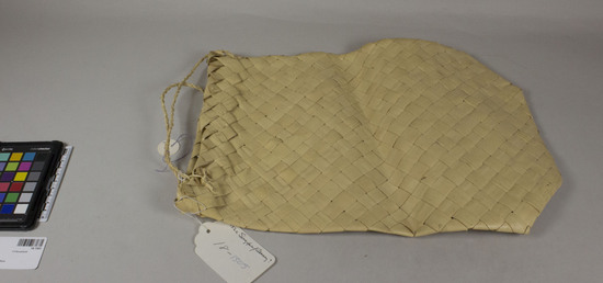 Hearst Museum object titled Bag, accession number 18-1505, described as Bag. Palm leaf, plain weave; with two twined handles attached to rim. Hexagonal shape. “From cottage industries.” Length 40.5 cm. Width 30 cm.