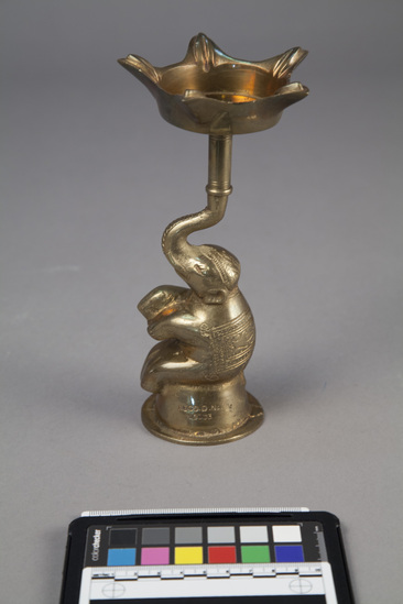Hearst Museum object titled Oil lamp, accession number 9-6619, described as Cast brass oil lamp; 5 spouted; base is sitting elephant; height 7  3/4 inches.