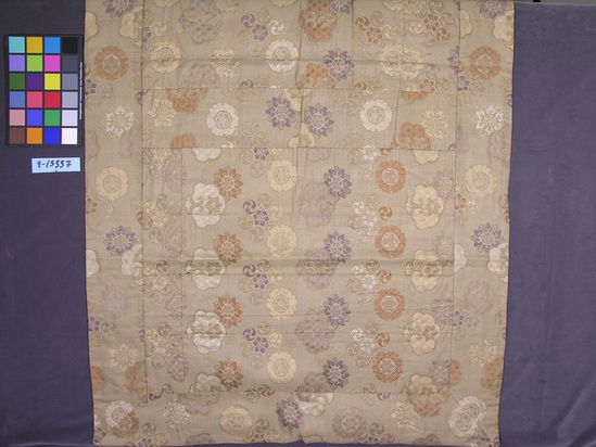 Hearst Museum object titled Robe, accession number 9-13557, described as Mantle; Rectangle.  Eight patches pieced together, with a wide border with mitred corners.  Tan silk ground with orange, purple, gold, and flat strap silver brocade in a geometricized floral pattern.  Diamond pattern in background.  Orange silk lining, also pieced, has some stains and deterioration.  Label sewn on lining reads “Clayes, San Francisco”.  Late 18th or early 19th century.  Buddhist priest’s mantle, fide Mr. Nagasaki of the Tokyo National Museum