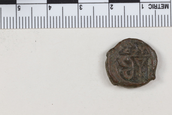 Hearst Museum object titled Coin: æ 10 nummia (decanummium), accession number 6-23168, described as Obverse: two frontal busts of soldiers each wearing a cross on his helmet separated by a cross Reverse: an I surmounted by a cross flanked by Left: [symbol]; Right: [symbol resembling w] below in ex. [four symbols] Denomination: decanummium Size: 1.6 cm Weight: 3.85 g Condition: fair Content: AE guilded Provenience: Naga-ed-Der, Egypt. Hoard of 68 coins (6-23121-88) Mint Date: Alexandria Heraclitus 610-14 A.D. Reference: Warwick Wroth. Byzantine Coins.