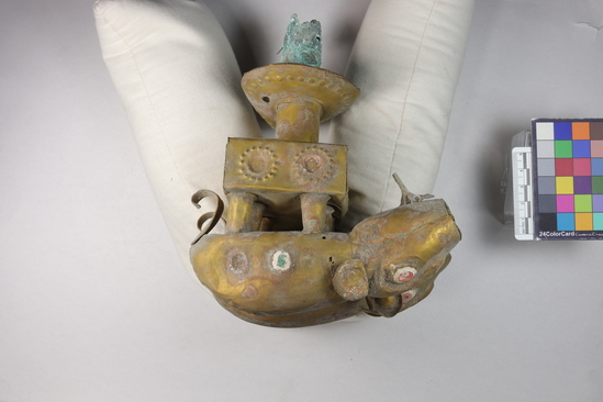 Hearst Museum object 12 of 29 titled Staff, accession number 16-20407a,b, described as Chimu style staff. a) gold-colored metal pigs (2) with applied metal curled tails and ears, red + white applied eyes.  pigs standing on rectangular metal block which is on staff head. b) wooden base with incised human figures (5)