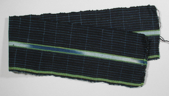 Hearst Museum object titled Textile fragment, accession number 5-11320, described as textile sample (section of narrow band weaving): black ground, with blue pin stripes, one narrow green silk stripe left edge, black selvages, center: Ikat: blue and white flanked by green silk.