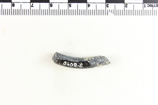 Hearst Museum object titled Bracelet fragment, accession number 9-8040, described as Glass bracelet frag.; black opaque, twisted, curved rod; 31 x 6 mm.