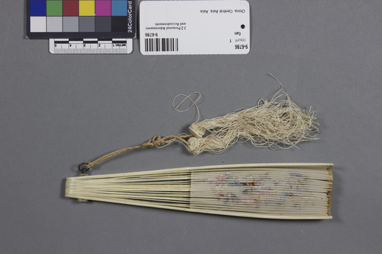 Hearst Museum object titled Fan, accession number 9-6786, described as Plastic and embroidered cloth fan; dragon-like creature; tassels; length 7.25 inches.