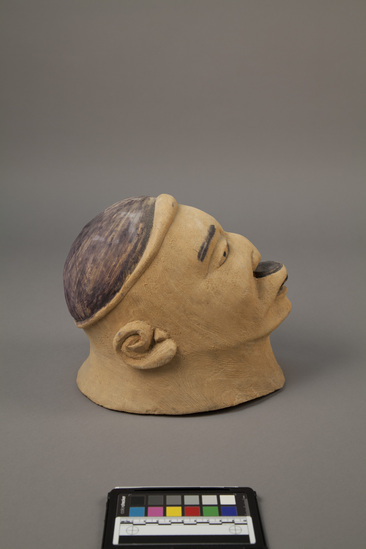 Hearst Museum object titled Carving, accession number 5-15520, described as Head, carved wooden (Balsa?). Hollow. Realistic features, black lip plug, black hair and eyebrows. Height 24 centimeters, length 23.5 centimeters. From Africa, East Tanzania and Mozambique, Makonde.