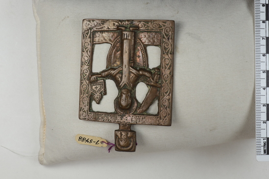 Hearst Museum object titled Icon, accession number 7-5488, described as Icon; metal; representing St. Nicholas of Mozhaysk; he holds a sword in his right hand and a church in his left; height 8 cm, width 5.8 cm. Cost $5.00.